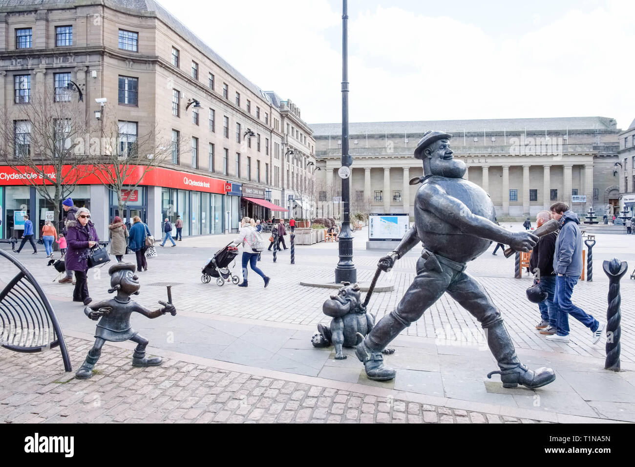 Dundee, Schottland, Großbritannien, 23. März 2019: Desperate Dan und anderen Zeichen Statuen in Dundee Stadtzentrum mit der Caird Hall im Hintergrund Stockfoto