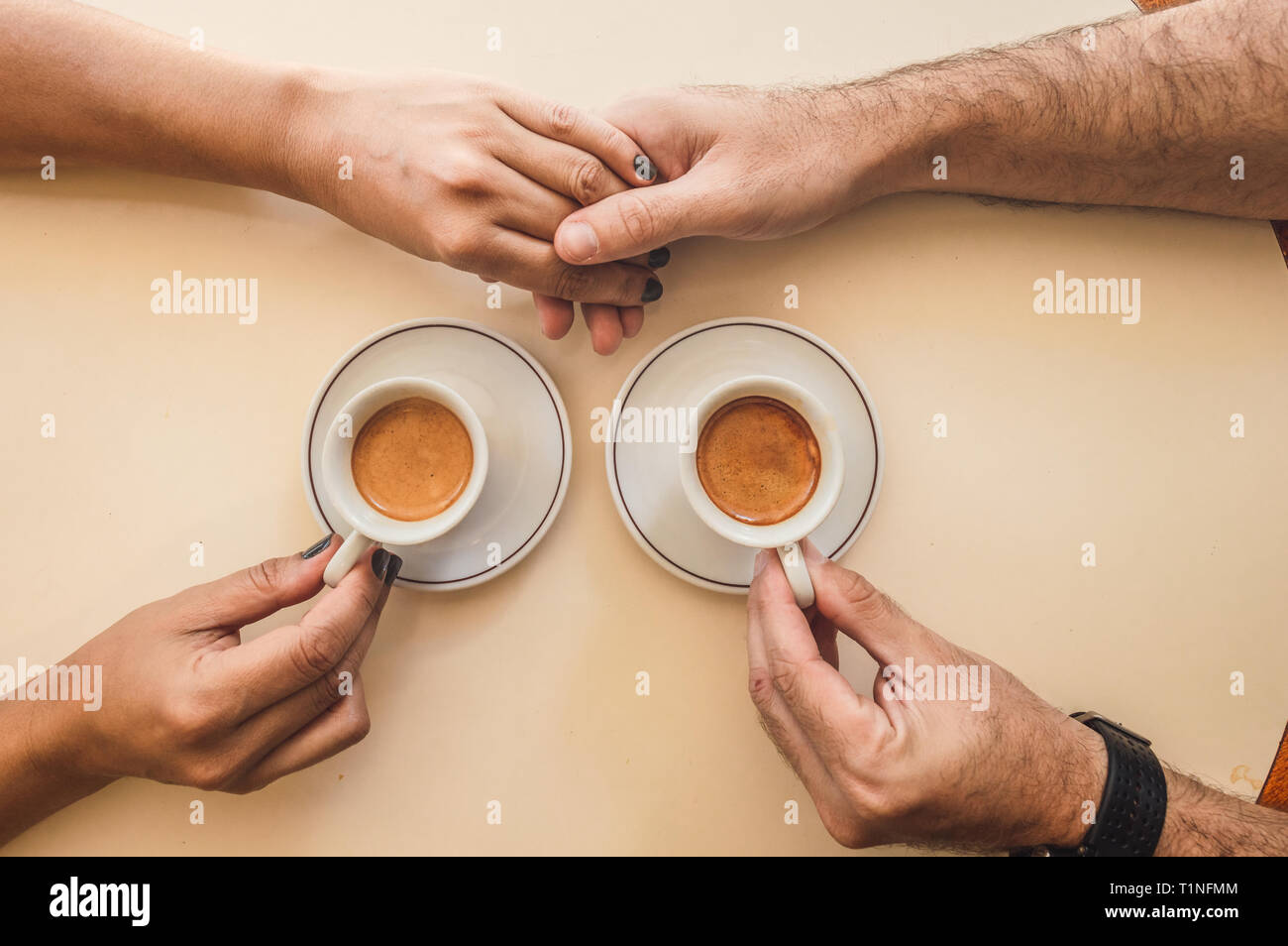 Paar Hände zu geben, während Sie einen Kaffee teilen Stockfoto