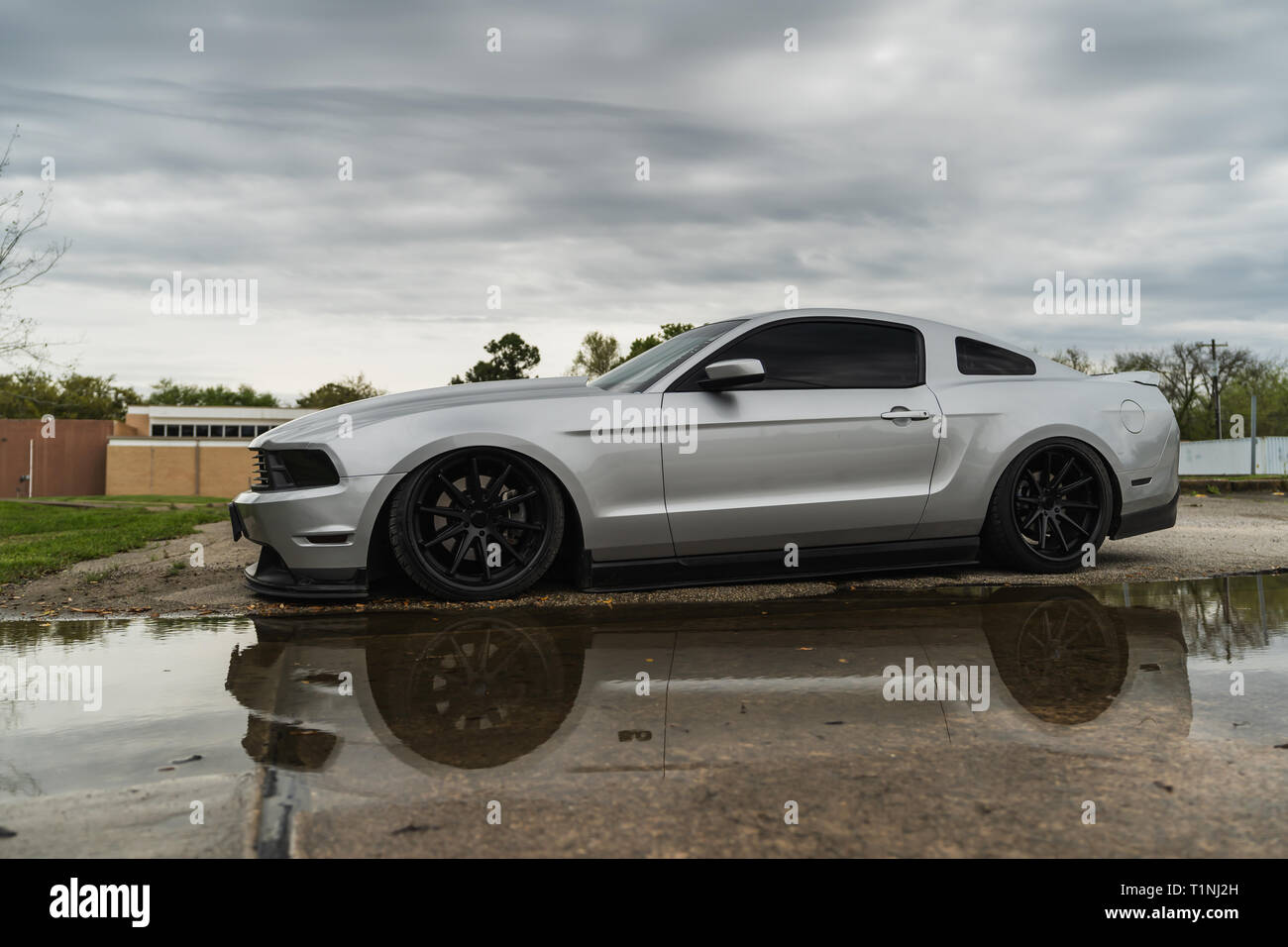 Silber American Muscle Car in Wasser bei bewölktem Himmel wider. Stockfoto