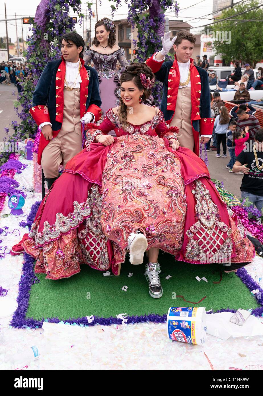 Lokale Debütantinnen und ihre Begleitpersonen tragen aufwendigen Kostümen, beim Reiten auf einem Float bei Washington's Birthday Celebration Parade in Laredo, TX USA Stockfoto
