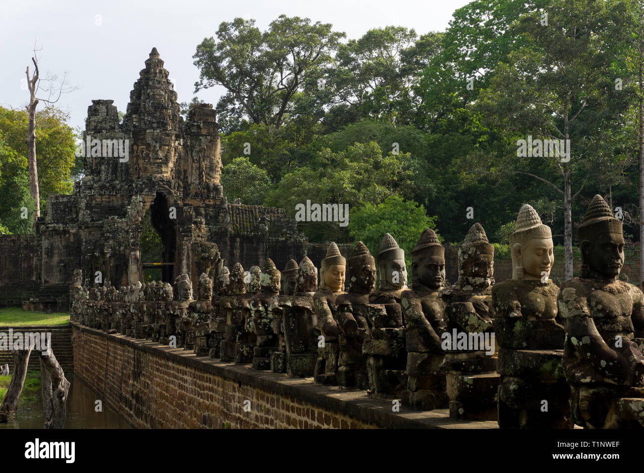 Schöne Stein Skulpturen säumen die Brücke, die das Südtor von Angkor Thom führt Stockfoto