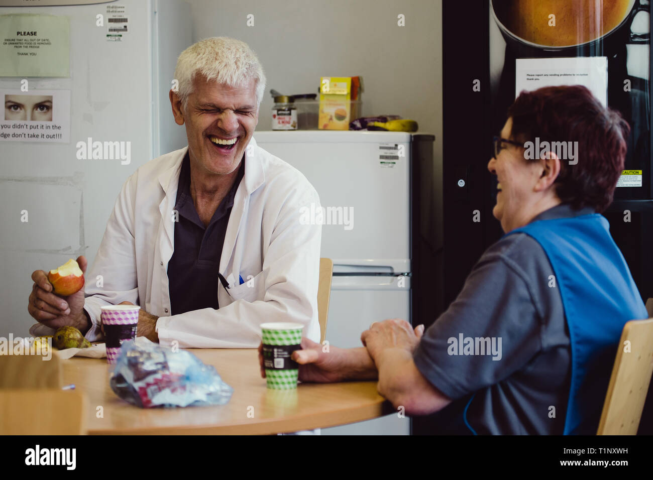 Arbeiter in einer Kantine Lachen beim Essen Mittagessen in einem Kent Werk in Großbritannien Stockfoto