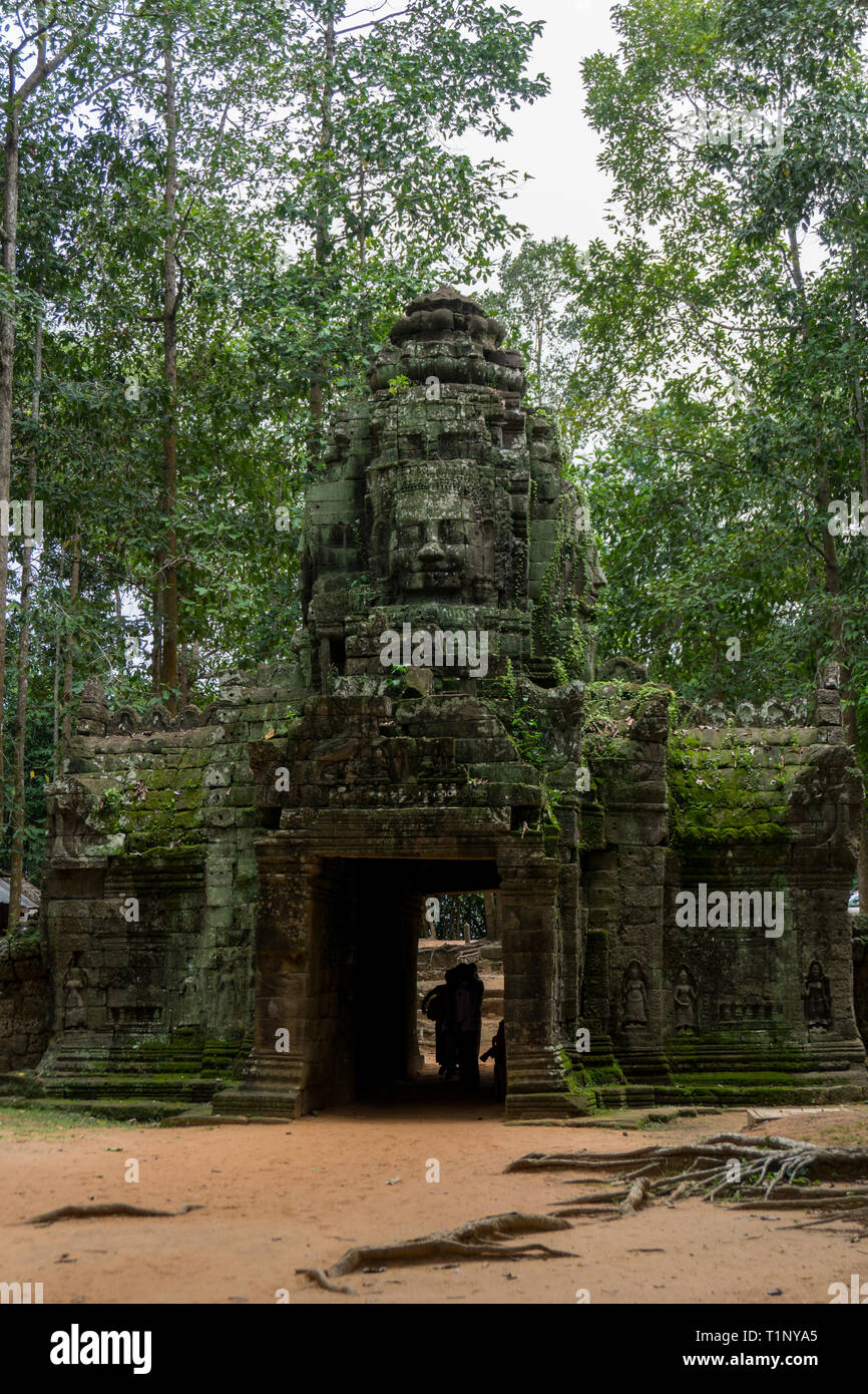 Touristen, die bei einem alten Angkor Gate in der Nähe von Angkor Wat Stockfoto