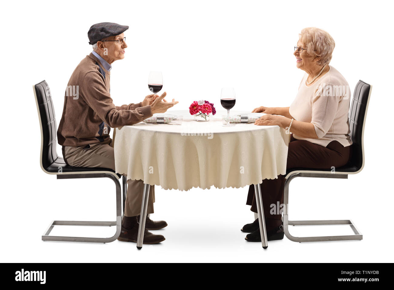 Älterer Mann und Frau beim Abendessen in einem Restaurant in der Tabelle auf weißem Hintergrund Stockfoto