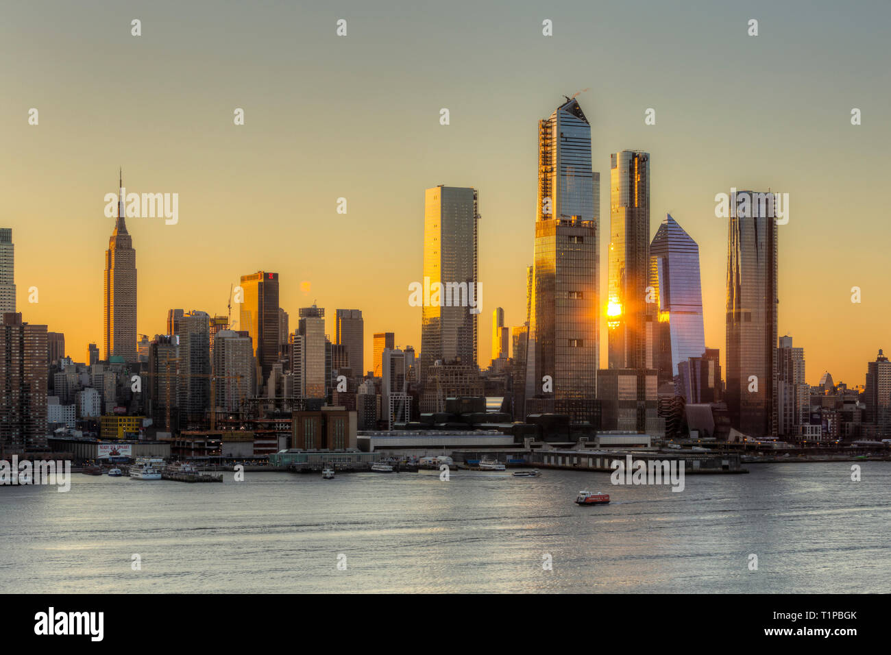 Das Sonnenlicht spiegelte sich bei Sonnenaufgang von der gemischt genutzten Hudson Yards-Entwicklung und anderen Gebäuden auf der Westseite von Manhattan in New York City wider. Stockfoto