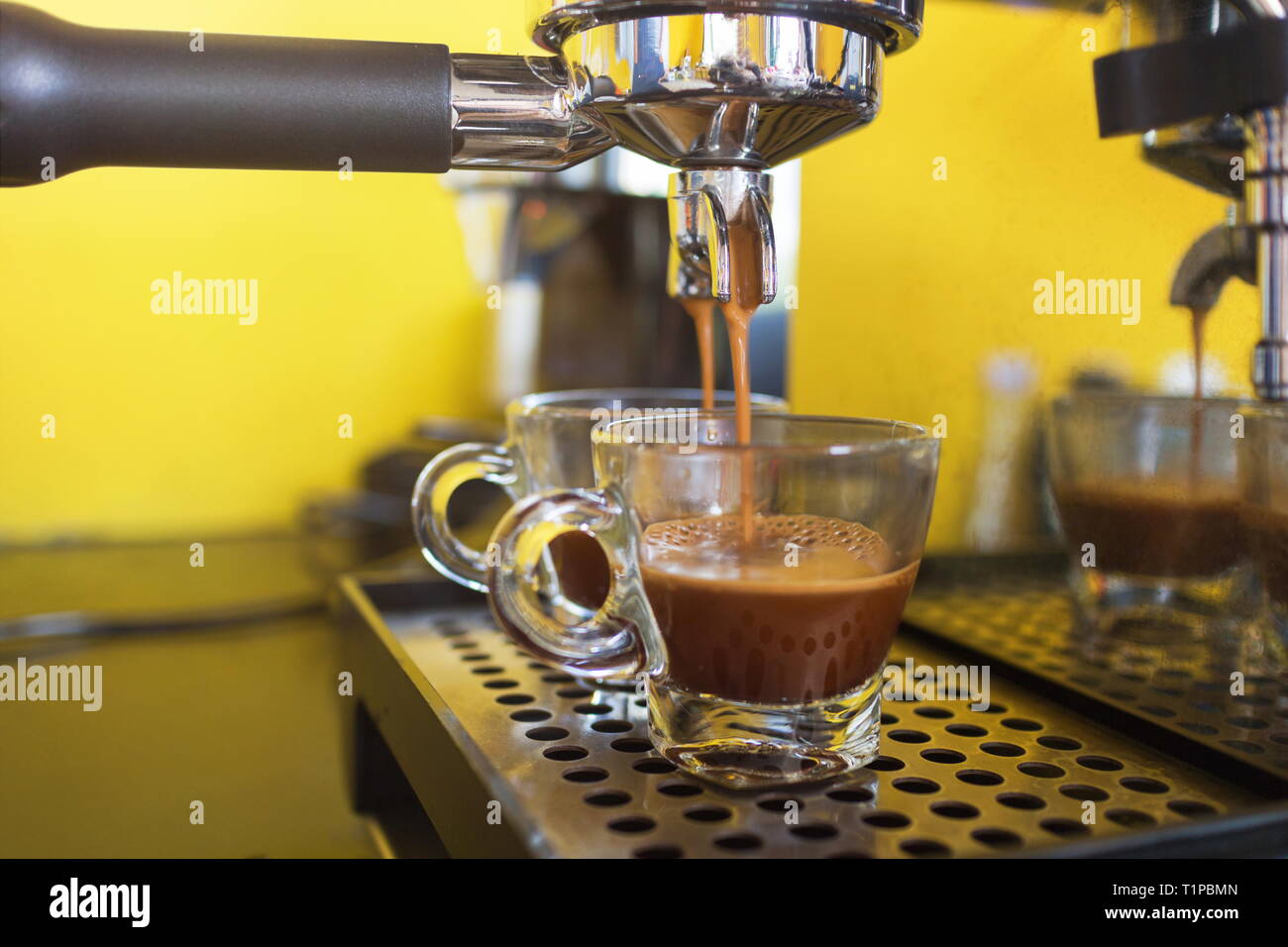 Kaffeemaschine bereitet frischen Kaffee und Gießen in cups im Cafe. Stockfoto