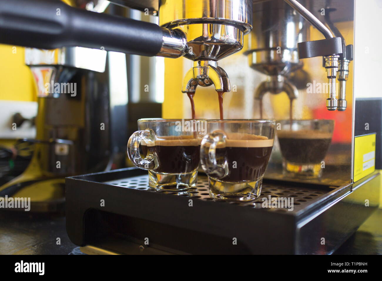 Kaffeemaschine bereitet frischen Kaffee und Gießen in cups im Cafe. Stockfoto