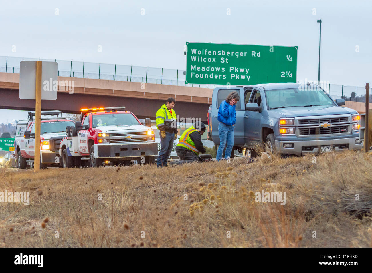 Frau Autofahrer Hilfe für Reifenpanne auf der Interstate 25 in Abend, Castle Rock Colorado USA. Foto im März getroffen. Stockfoto