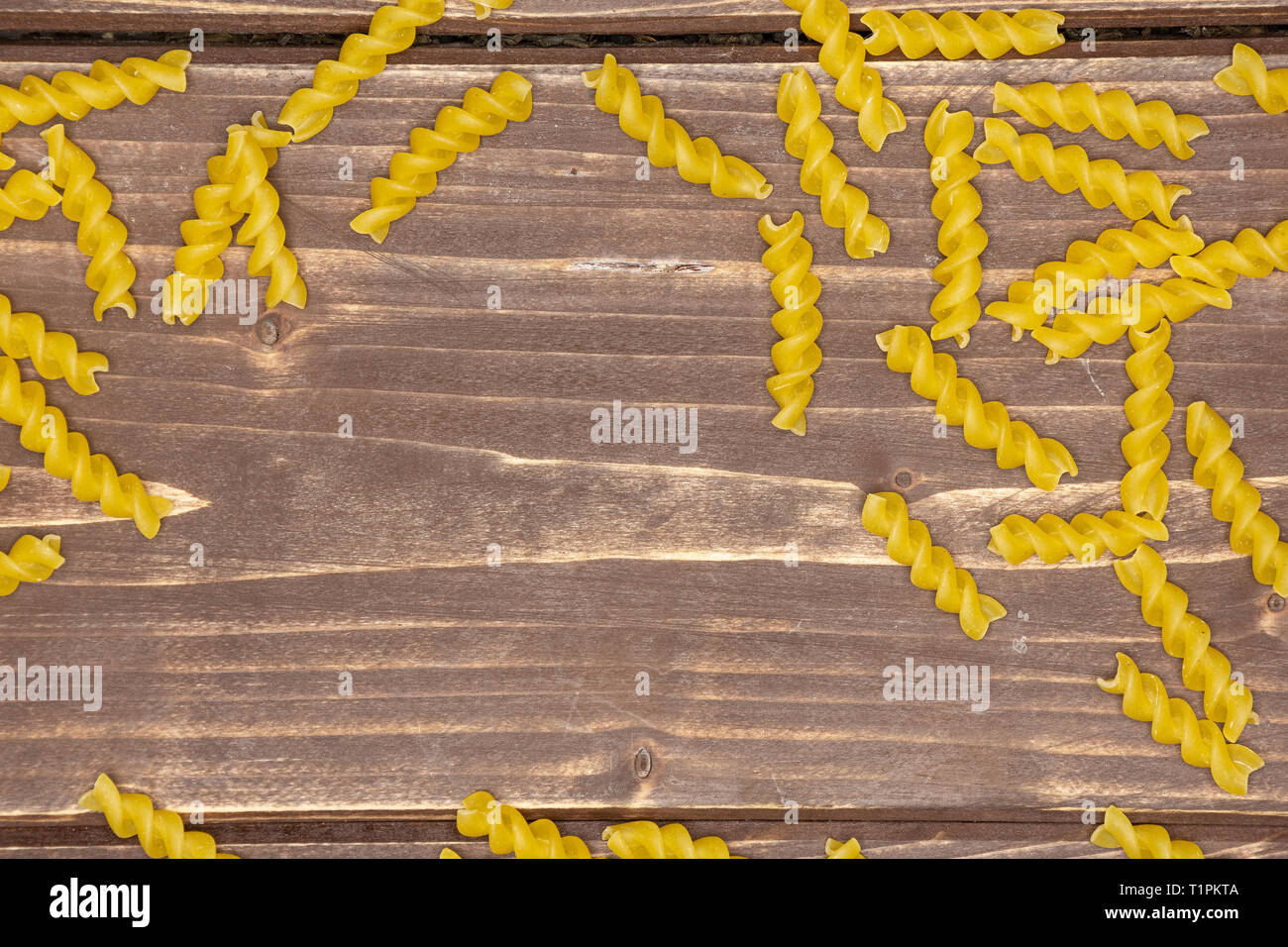 Viele Stücke von Raw italitan gelbe Nudeln torti flatlay auf braunem Holz Stockfoto