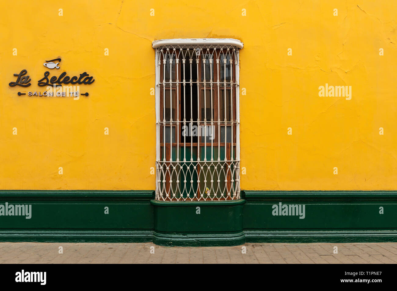 Gelbe und grüne Fassade im Zentrum von Trujillo im Kolonialstil Architektur mit Gusseisen Fenster Dekoration, Peru. "Wählen Sie Kaffee Salon'. Stockfoto