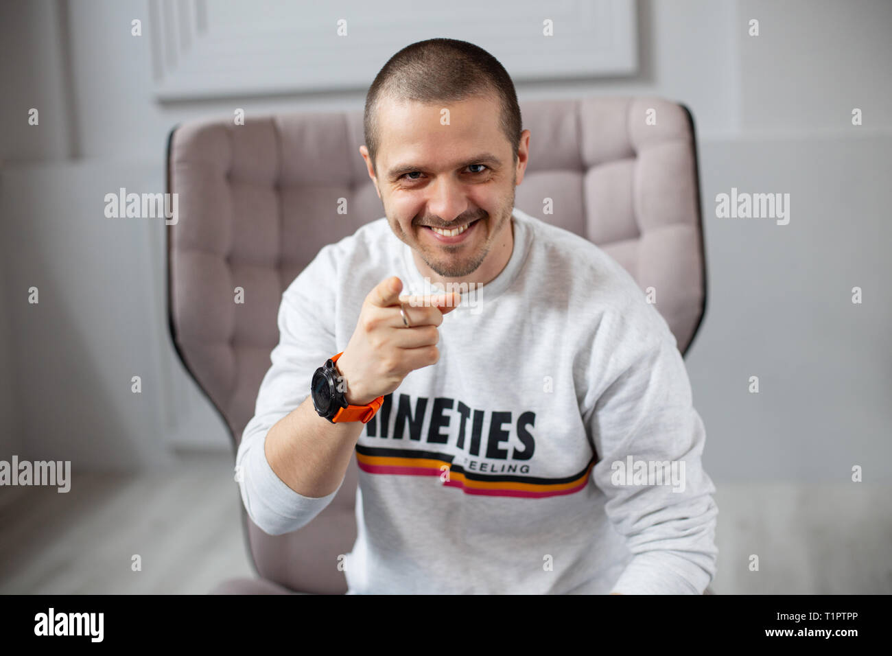 Lächelnde Menschen, die auf der Kamera sitzt in der modernen Innenausstattung Stockfoto