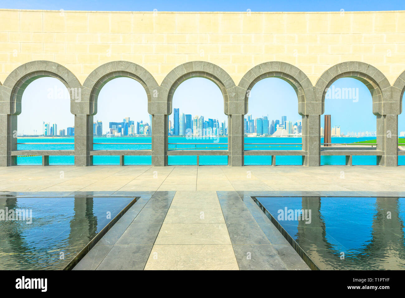 Doha, Katar - Februar 16, 2019: Serie von Bögen Reflexionen in einem Pool Springbrunnen im Museum für Islamische Kunst beliebte Strandpromenade. Naher Osten Stockfoto