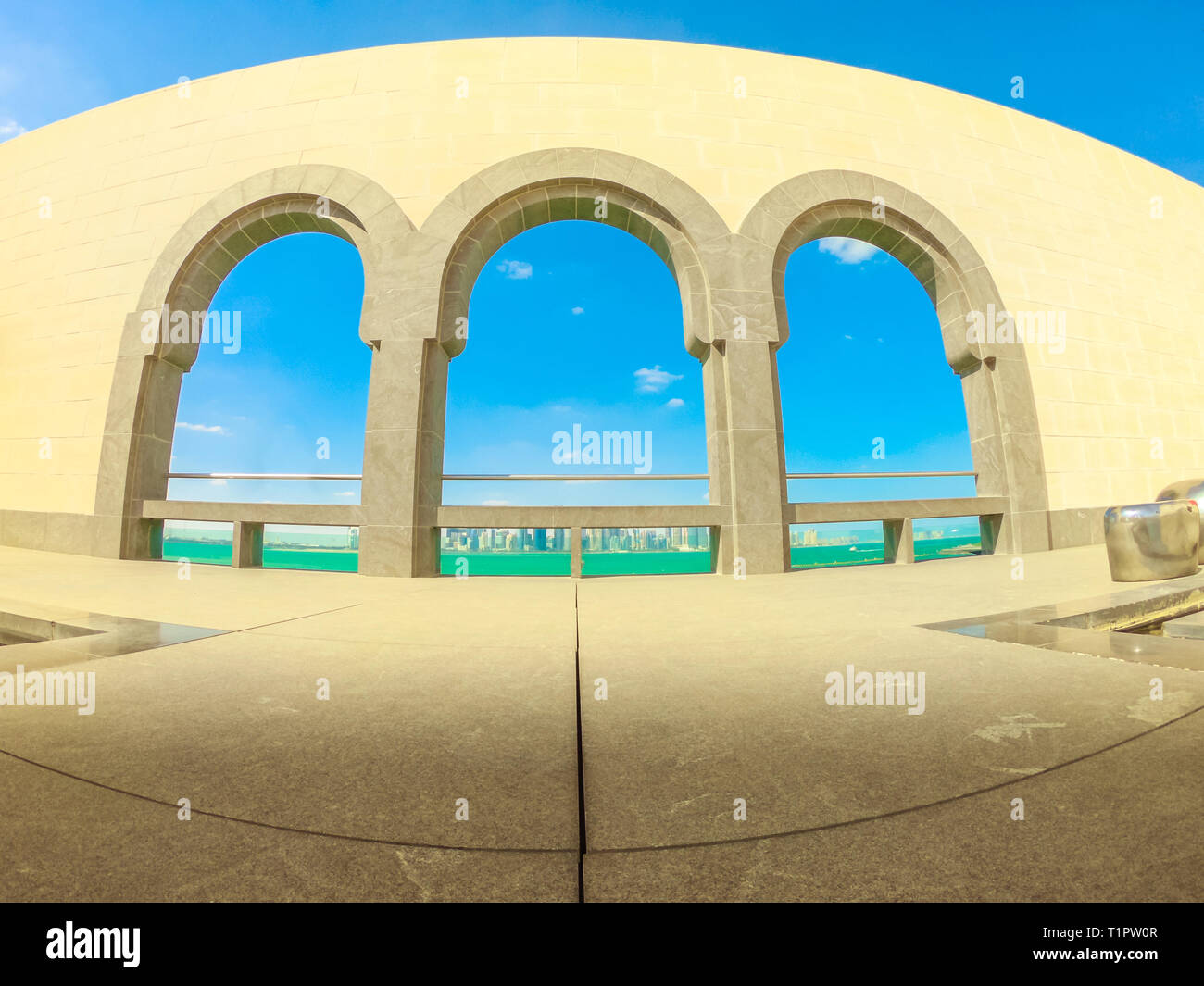 Doha, Katar - 5. Januar 2019: Weitwinkelaufnahme der Bögen des Museum für Islamische Kunst und Doha West Bay Skyline in einem sonnigen Tag. Wasser in der Nähe von Doha. Stockfoto Doha, Katar - 5. Januar 2019: Weitwinkelaufnahme der Bögen des Museum für Islamische Kunst und Doha West Bay Skyline in einem sonnigen Tag. Wasser in der Nähe von Doha. Stockfoto