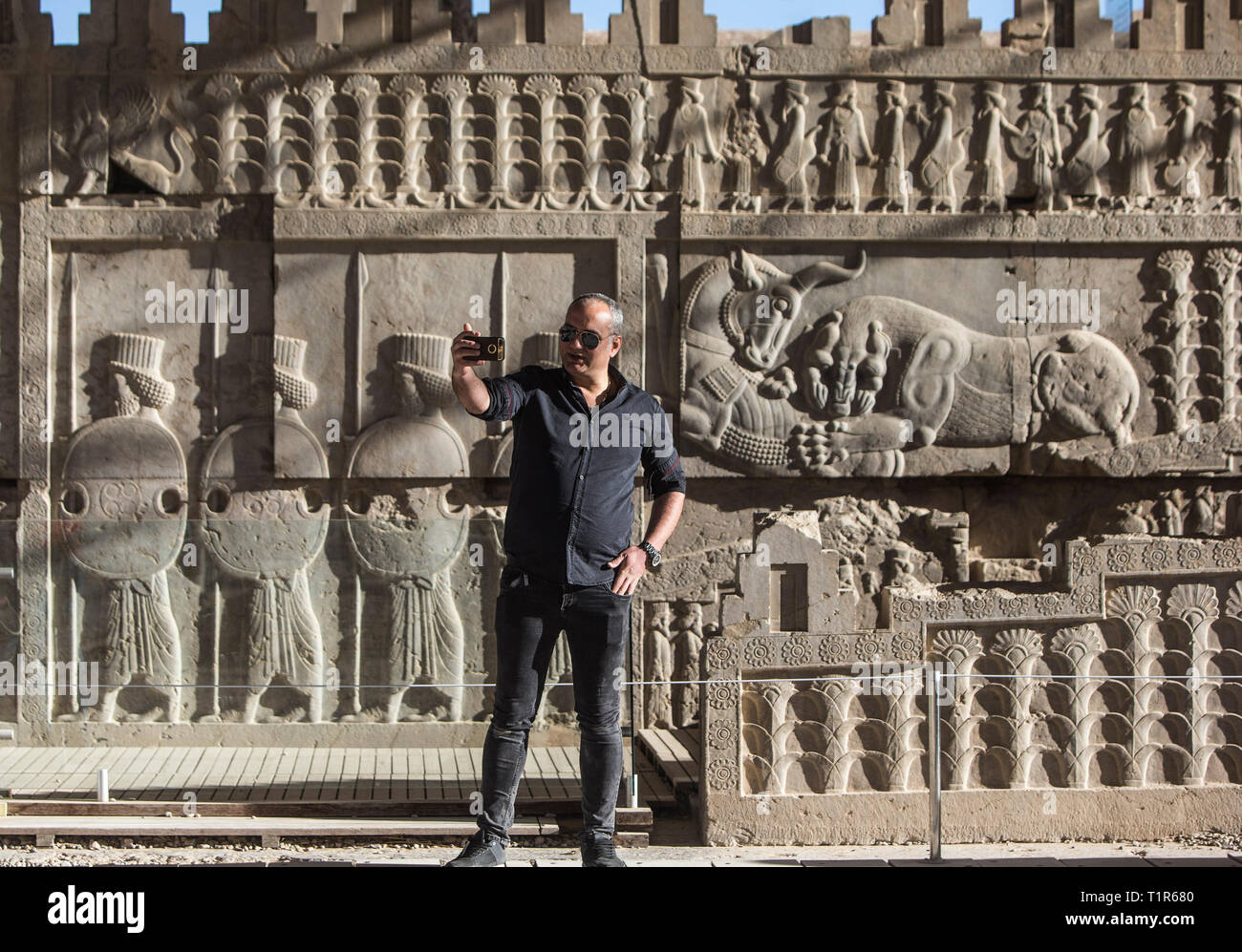 (190328) - Shiraz, 28. März 2019 (Xinhua) - ein Mann nimmt selfie in der alten persischen Stadt Persepolis außerhalb Shiraz, südlichen Iran am 27. März 2019. Persepolis, ein UNESCO-Weltkulturerbe, war die Hauptstadt des achämenidischen Reichs von Persien (550-330 v. Chr.). Es war der König der Könige, Darius I, der einen eindrucksvollen Schlossanlage durch mesopotamische Modelle inspiriert. Die Bedeutung und die Qualität des monumentalen Ruinen machen es zu einem einzigartigen archäologischen Stätte. (Xinhua / Ahmad Halabisaz) Stockfoto