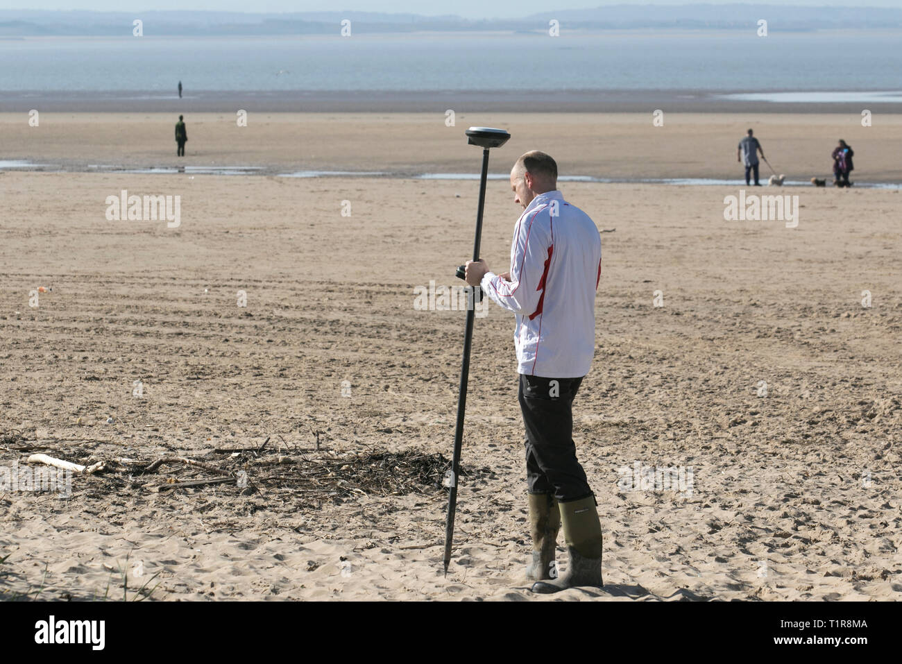 Strandbefragung durch Mitarbeiter des Sefton council, die Leica GPS-Vermessungsgeräte als Teil der Küstenüberwachung verwenden, die alle 6 Monate an einem ausgedehnten Sandstrand durchgeführt wird, um Erosion und Akkretion zu überwachen. Stockfoto