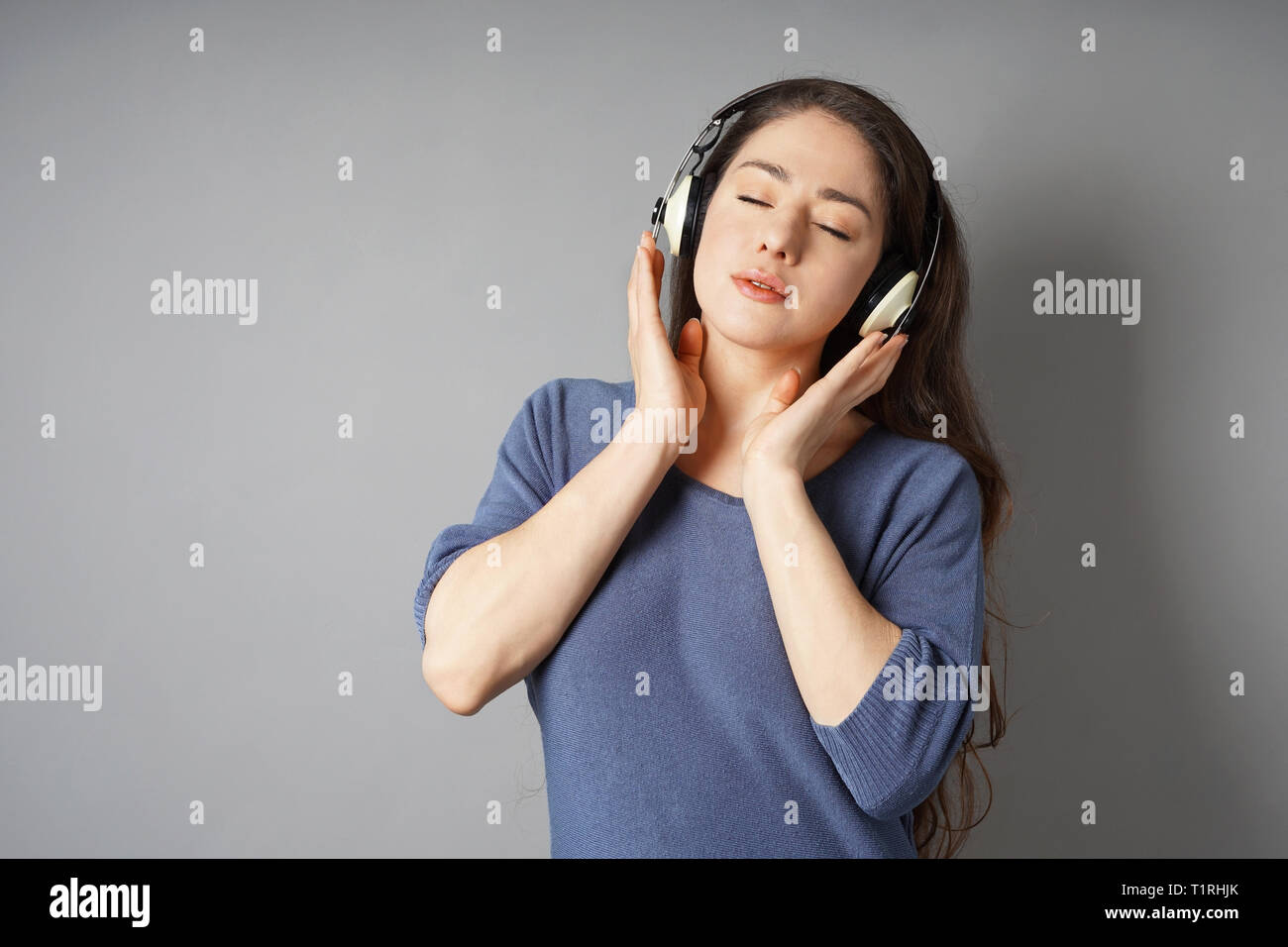 junge Frau mit Kopfhörern Musik hören Stockfoto