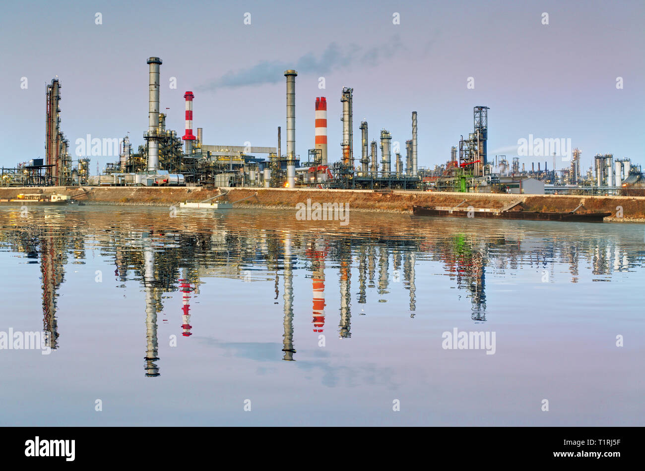 Ölraffinerie in der Nacht mit Reflexion im Wasser Stockfoto Ölraffinerie in der Nacht mit Reflexion im Wasser Stockfoto