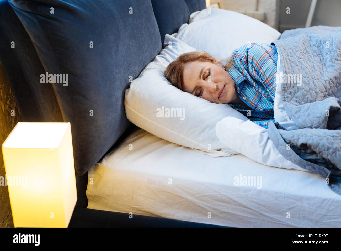 Nach Licht - behaarte Frau liegt mit geschlossenen Augen mit warmen Decke abgedeckt Stockfoto