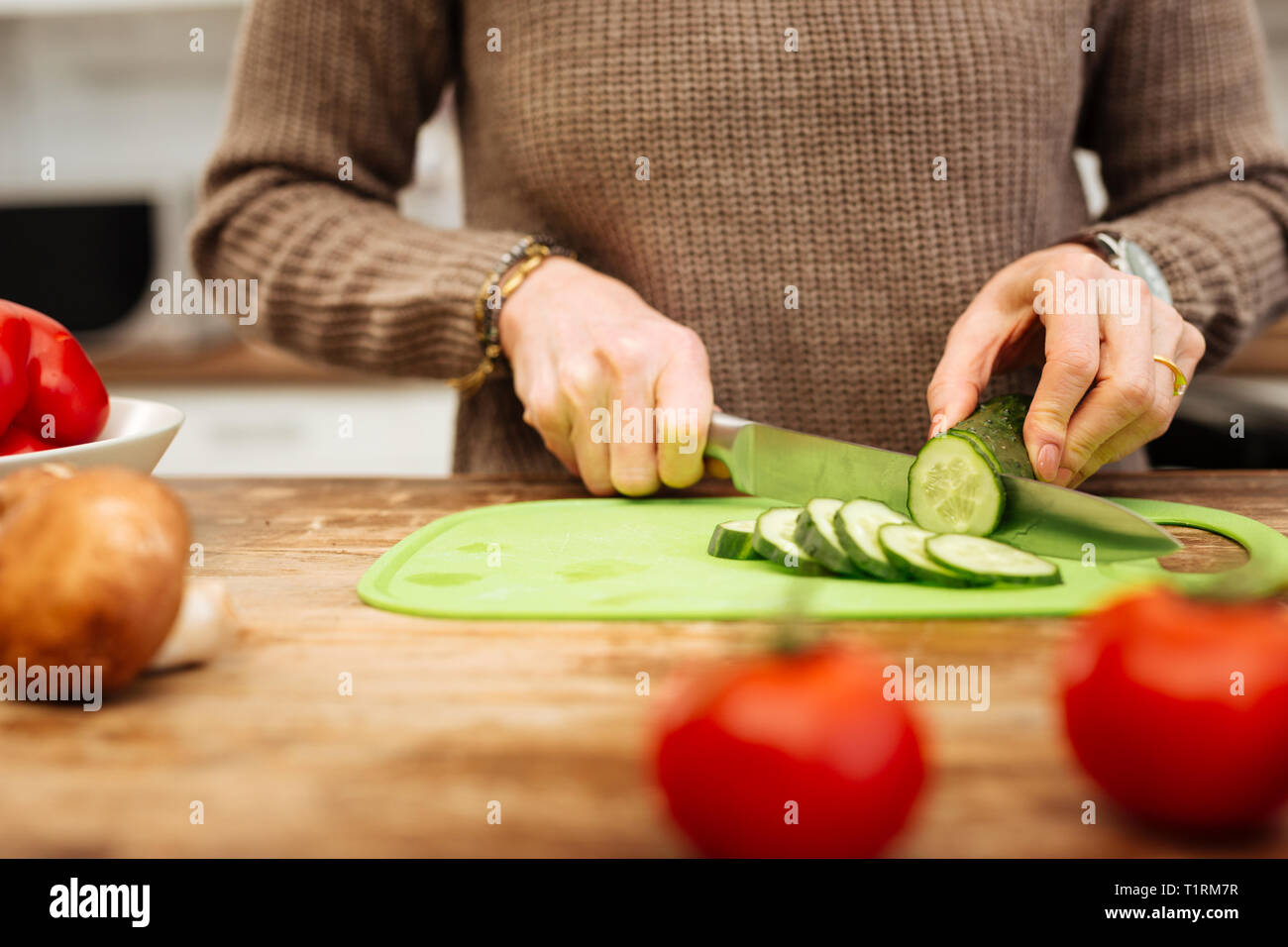 Genaue Frau in der Küche und Zerkleinern von Zutaten für Salat Stockfoto