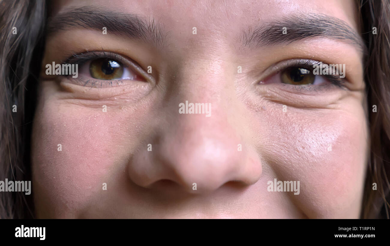 Closeup Schießen von jungen Hübschen kaukasischen Frauen Gesicht mit Augen geradeaus auf Kamera mit lächelnden Gesichtsausdruck Stockfoto
