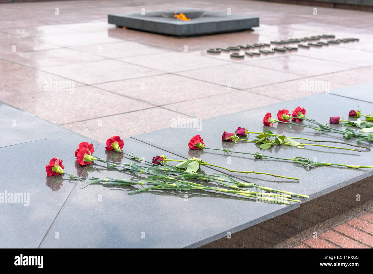 BREST, BELARUS - 28. JULI 2018: Blumen am Grab des Unbekannten Soldaten und das Ewige Licht. Der Titel sagt "Herrlichkeit für die Helden, die kämpften, t Stockfoto