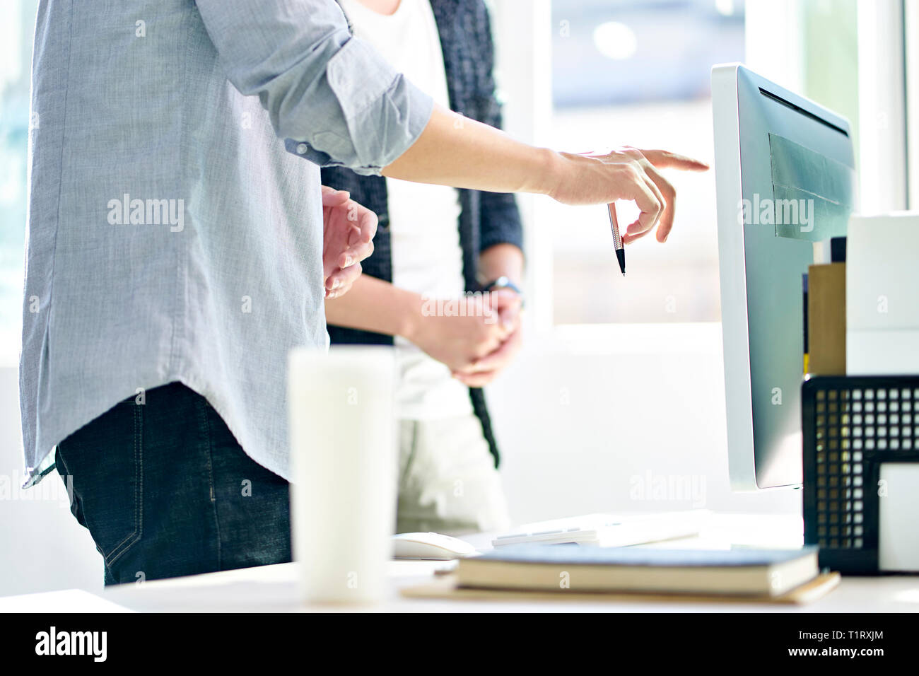 Asiatische Führungskräfte stehen vor der Diskussion von Plänen in modernen Büro. Stockfoto