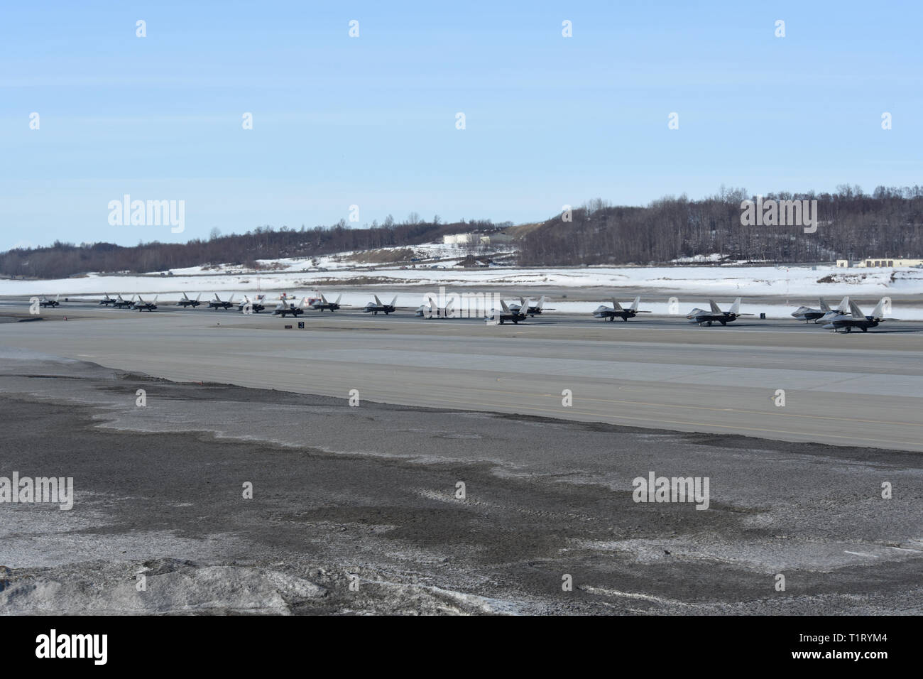 F-22 Raptors aus der 3 Flügel und 477th Fighter Group beteiligen sich in einer engen Formation Taxi, bekannt als ein Elephant Walk, 26. März 2019, während eines Polar Kraft Übung in Joint Base Elmendorf-Richardson, Alaska. Dieser zweiwöchige Übung gibt staffeln die Möglichkeit, ihre Fähigkeiten unter Beweis zu stellen, Bereitstellung und überwältigende Combat Power liefern. (U.S. Air Force Foto von Sheila deVera) Stockfoto