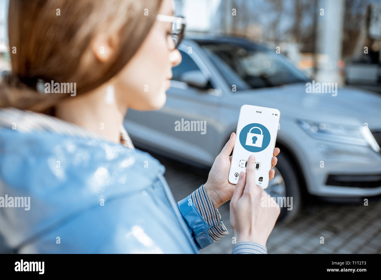 Frau Verriegelung auto mobile Anwendung auf einem Smartphone. Konzept der Fernbedienung und Auto Schutz durch das Internet Stockfoto