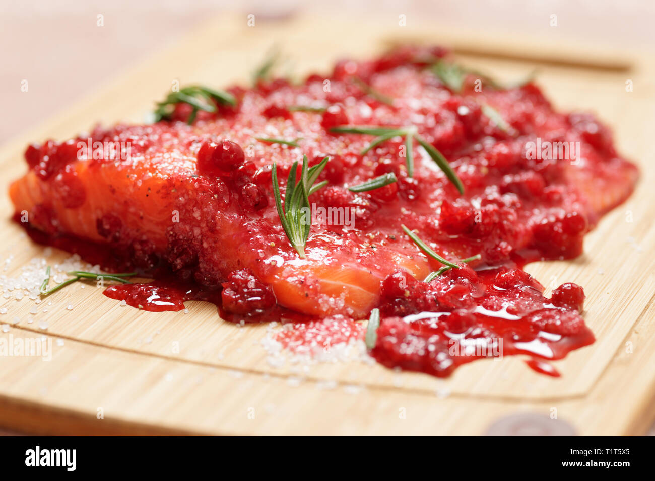 Lachssteak, mariniert in Salz mit Rosmarin und redberries, close-up Stockfoto