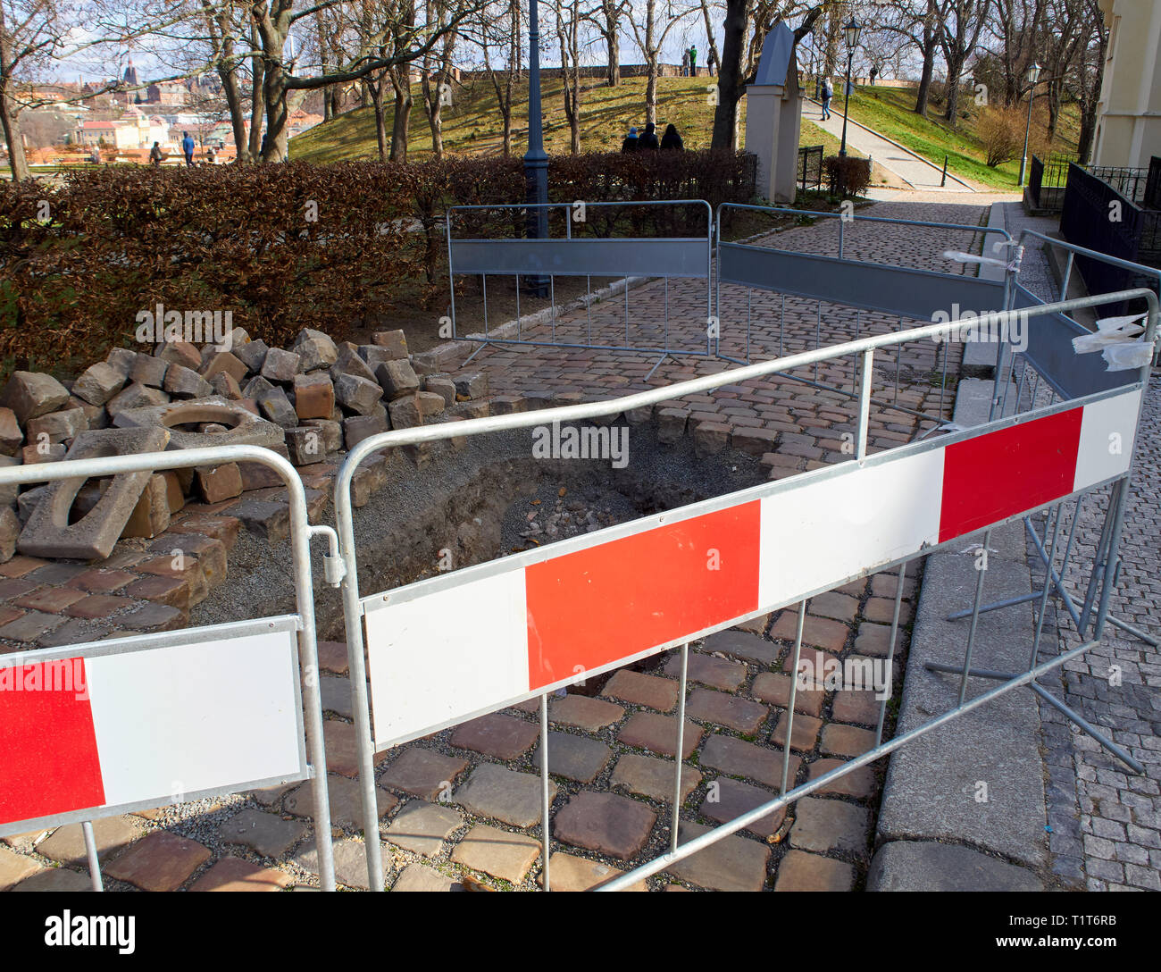 Dugged Gehweg und Loch im Bürgersteig. Der Schutz blockieren. Park mit Bäumen in der Stadt. Stockfoto