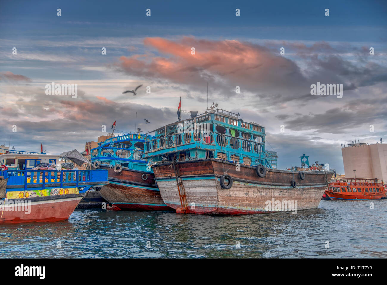 Alte hölzerne Asiatischen Boote im Hafen von Dubai am Persischen Golf bei Sonnenuntergang in den Vereinigten Arabischen Emiraten günstig Stockfoto