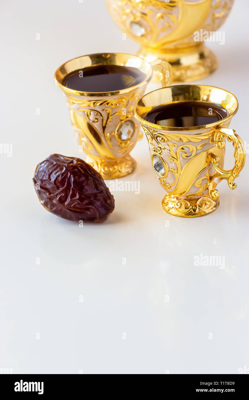 Stillleben mit traditionellen Goldenen arabischen Kaffee mit dallah und Schale. Weißer Hintergrund. Ramadan Konzept. Stockfoto