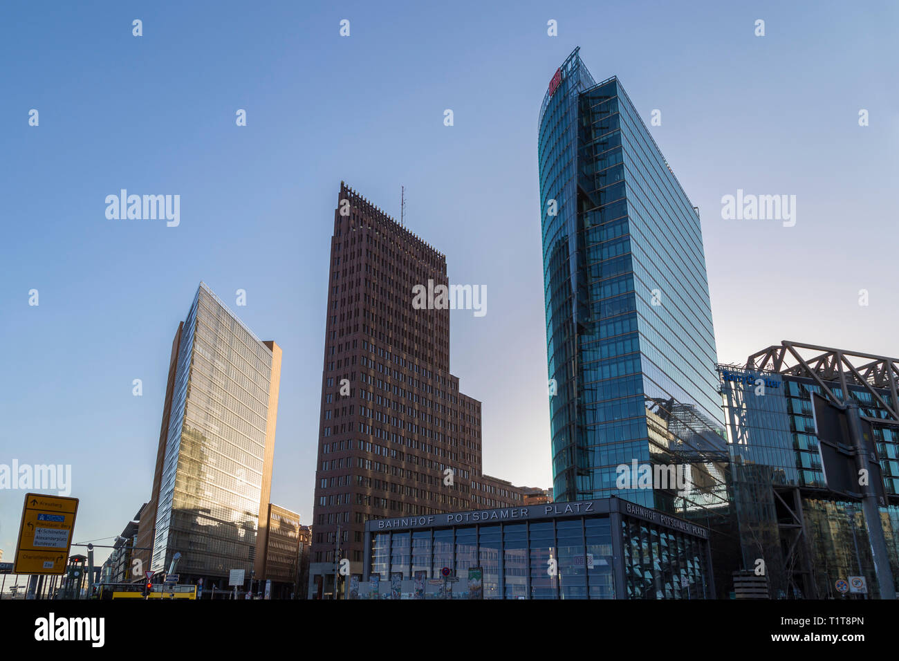 Modernes hohes Gebäude gegen den klaren, blauen Himmel und Eingang Bahnhof am Potsdamer Platz im Zentrum von Berlin, Deutschland, an einem sonnigen Tag. Stockfoto