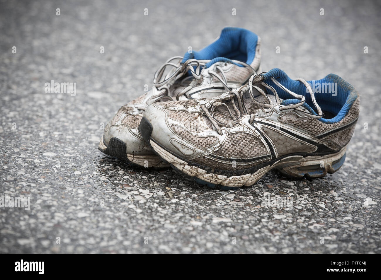 Abgenutzt, schmutzig, stinkend und alte Laufschuhe auf einer Asphaltstraße.  Straße, Ausdauer, Marathon und aktiven Lebensstil Konzept Stockfotografie -  Alamy