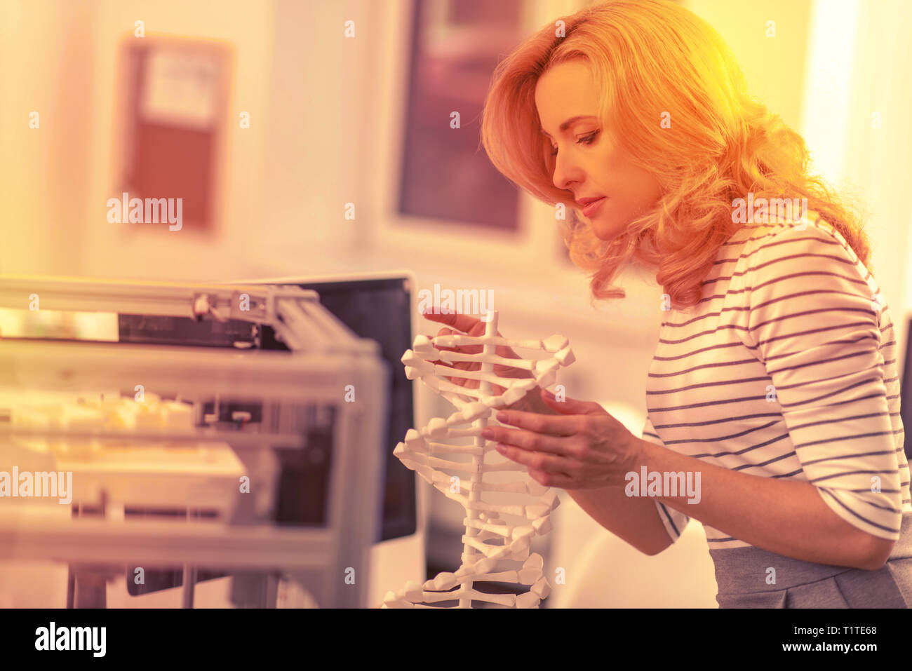 Smart Dame an ein Modell einer DNA-Kette auf der Suche interessiert. Stockfoto