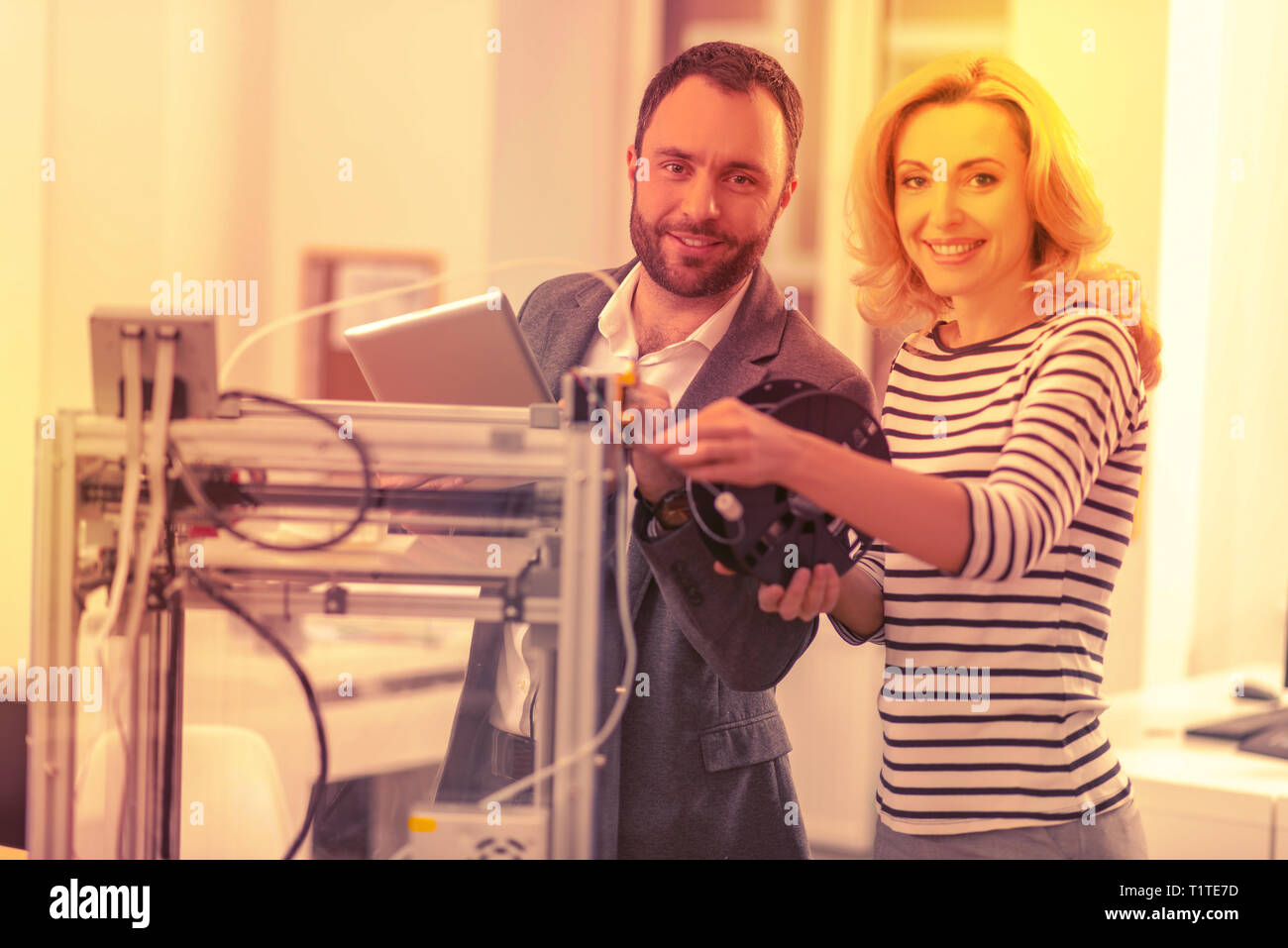 Begeisterte Erwachsene arbeiten zusammen Ein 3D-Drucker zu setzen. Stockfoto