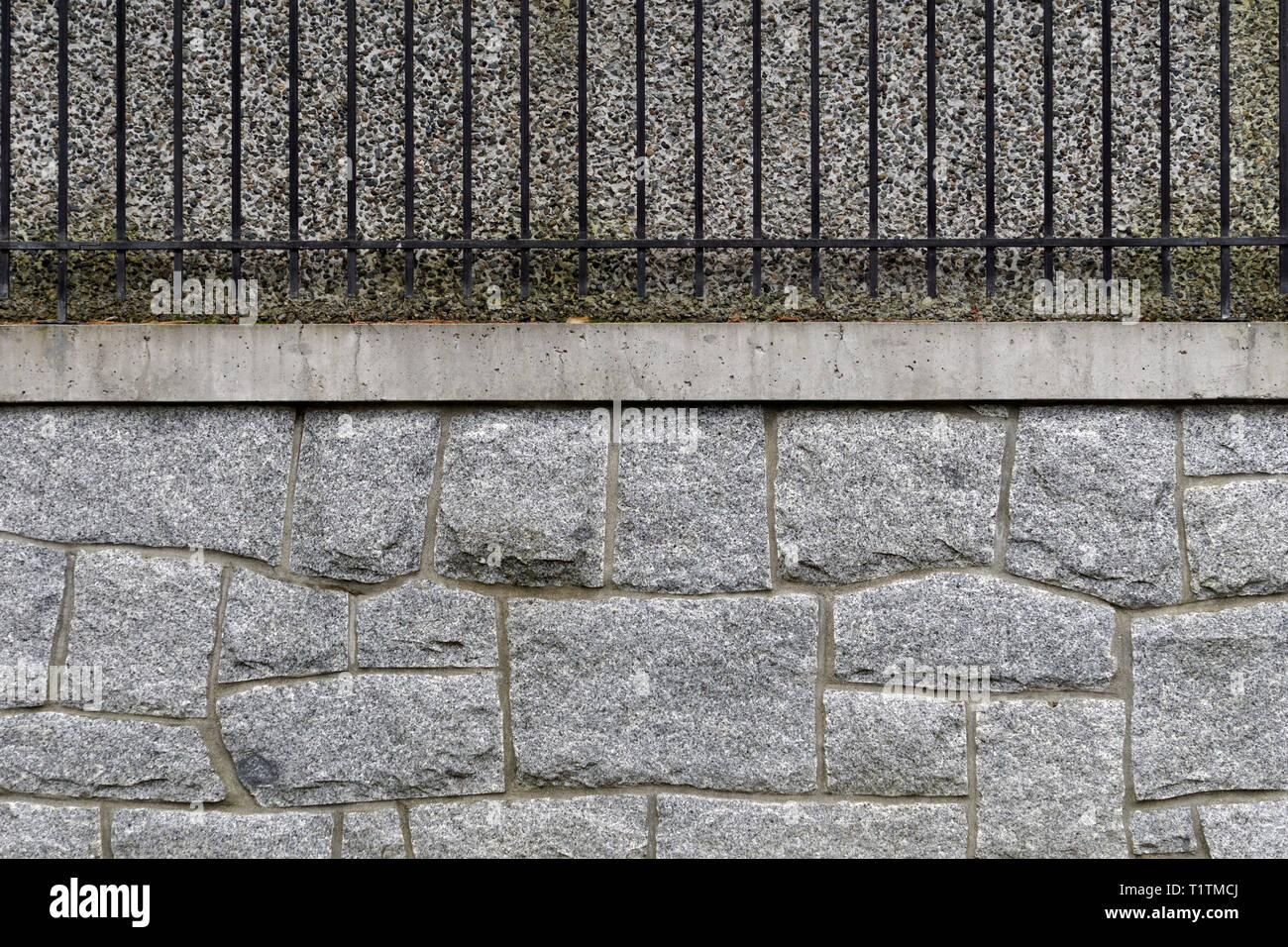 Fläche teilen Granit stein Wand mit Beton und Eisen Geländer gegen ein Stuck Wand Stockfoto