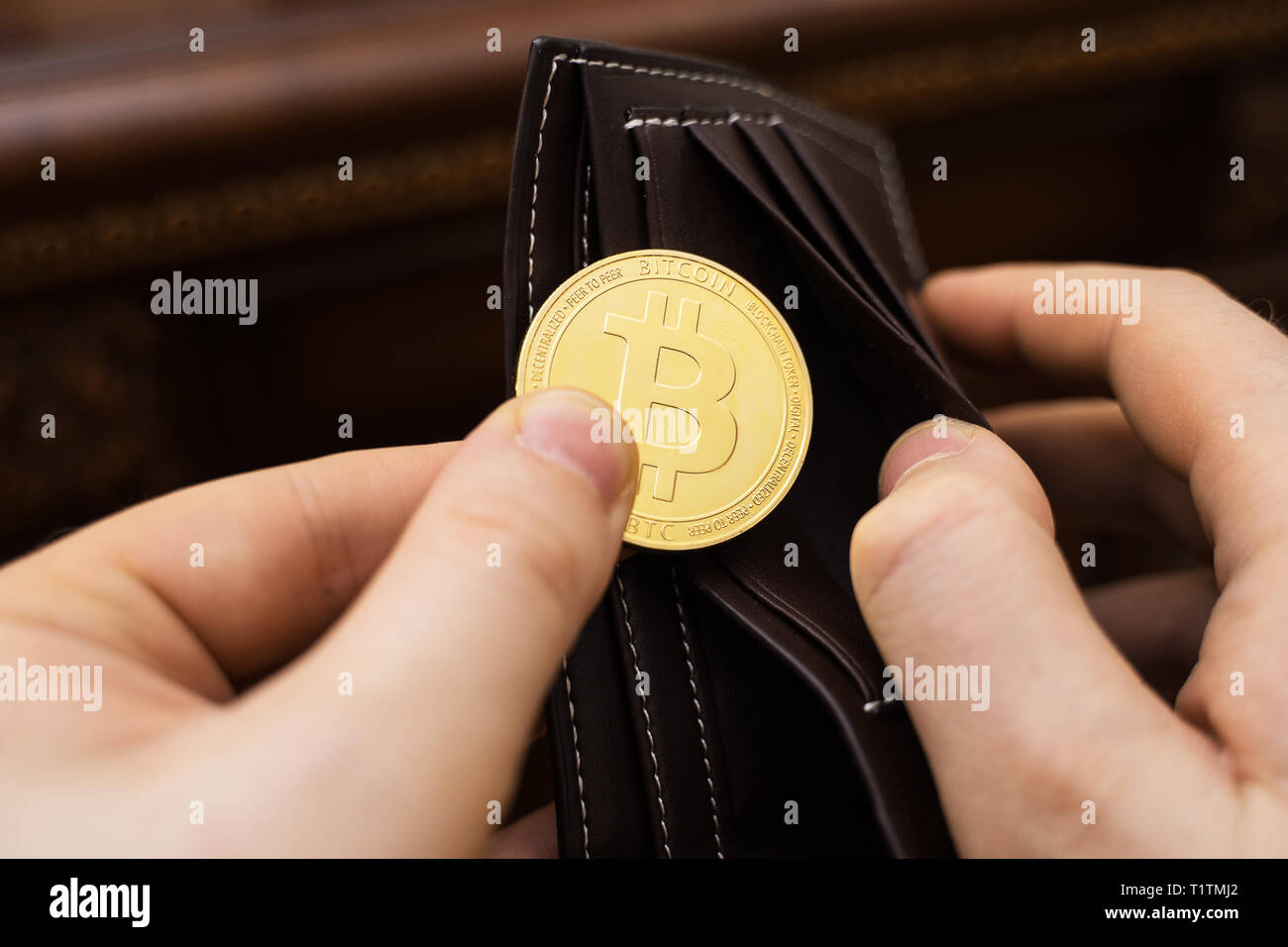 Mann hält physische Version von Golden bitcoin. Stockfoto