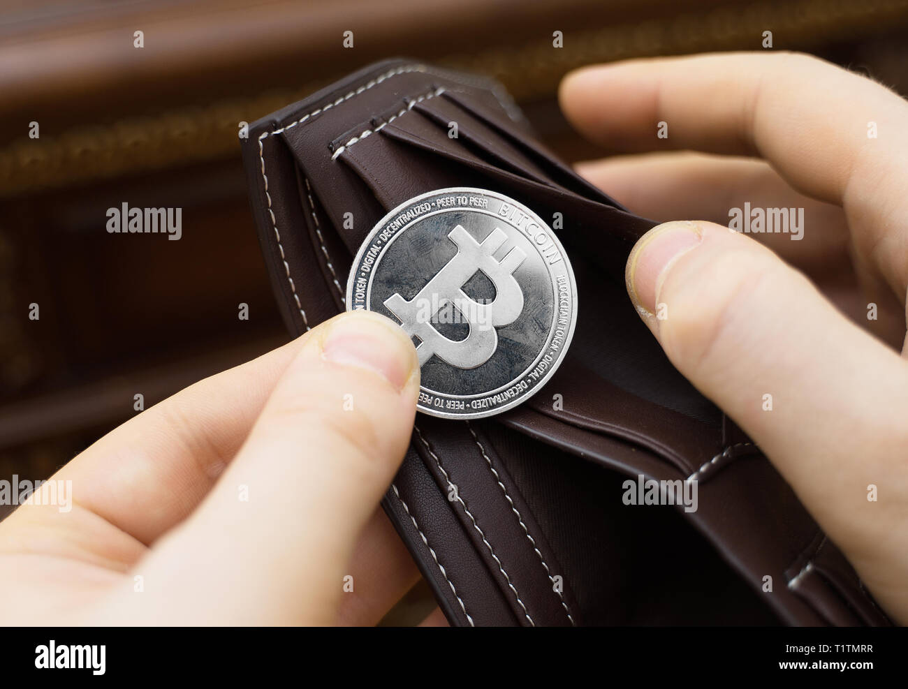Mann hält physische Version von Silber bitcoin. Stockfoto