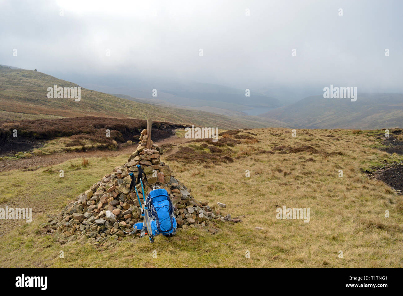 William Clough Pfad Cairn mit Rucksack und Wanderstöcke auf Kinder Scout, Derbyshire Stockfoto