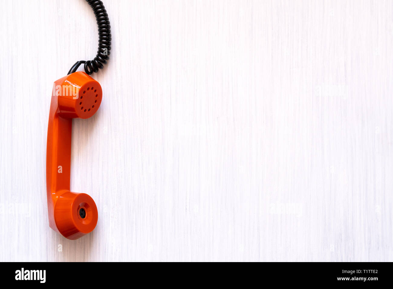 Orange Telefon griff nach unten hängend an einer Schnur. Urgent business.  Ungelöstes Problem. In Kontakt zu kommen Stockfotografie - Alamy