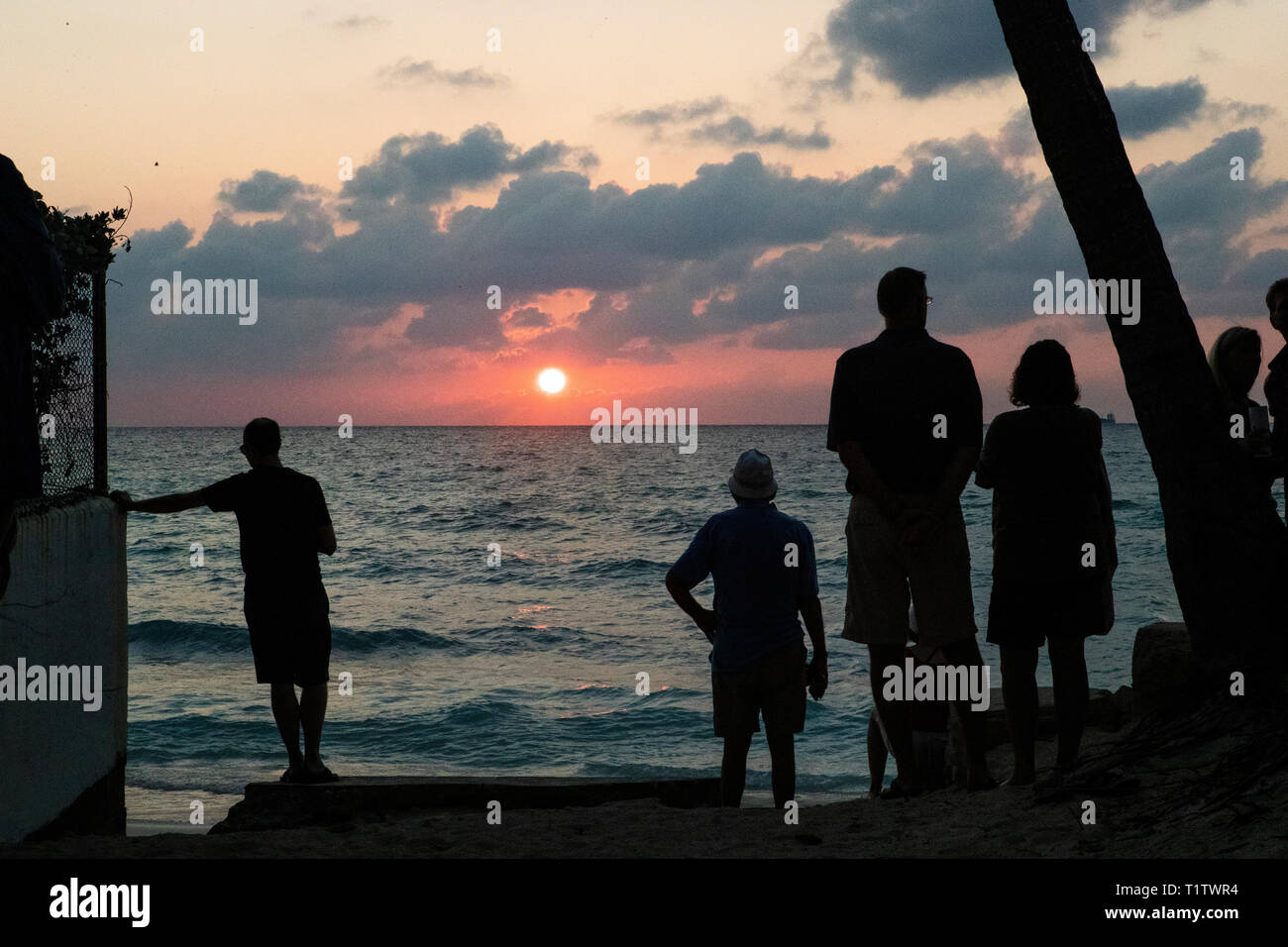 Menschen beobachten Sie den Sonnenuntergang über dem Meer in George Town, Grand Cayman in der Cayman Islands. Stockfoto