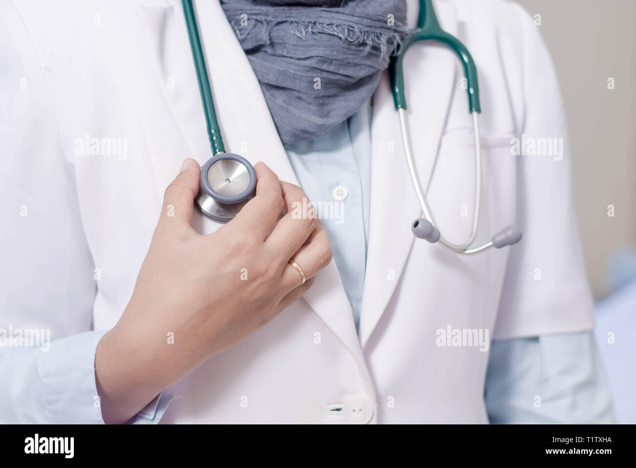 Vorderansicht Körper Teil des Hijab Ärztin Hand stetoschope in einem Krankenhausbett Zimmer Stockfoto