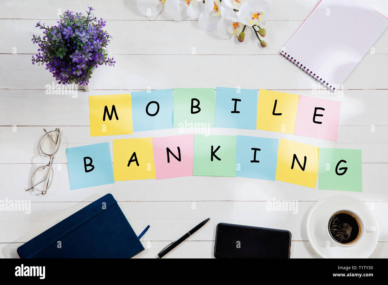 MOBILE BANKING. Nachricht an bunten Hinweis Papiere auf dem Schreibtisch Hintergrund. Lifestyle, Business, Office, finanzieren, planen, Erfolg, Bank und Management Konzept. Top oder flach. Stockfoto