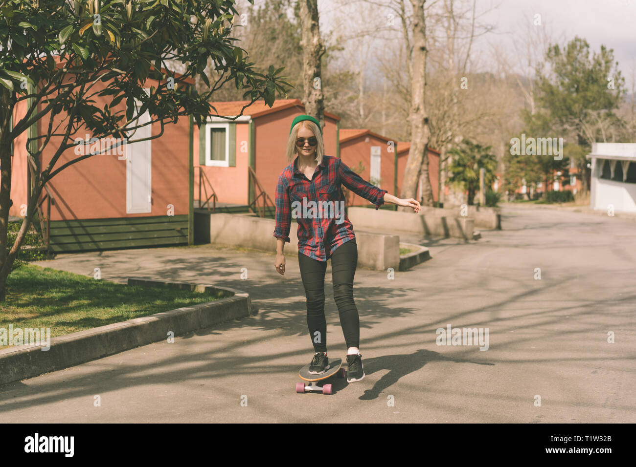 Blond hipster Mädchen reiten ein Skateboard Stockfoto