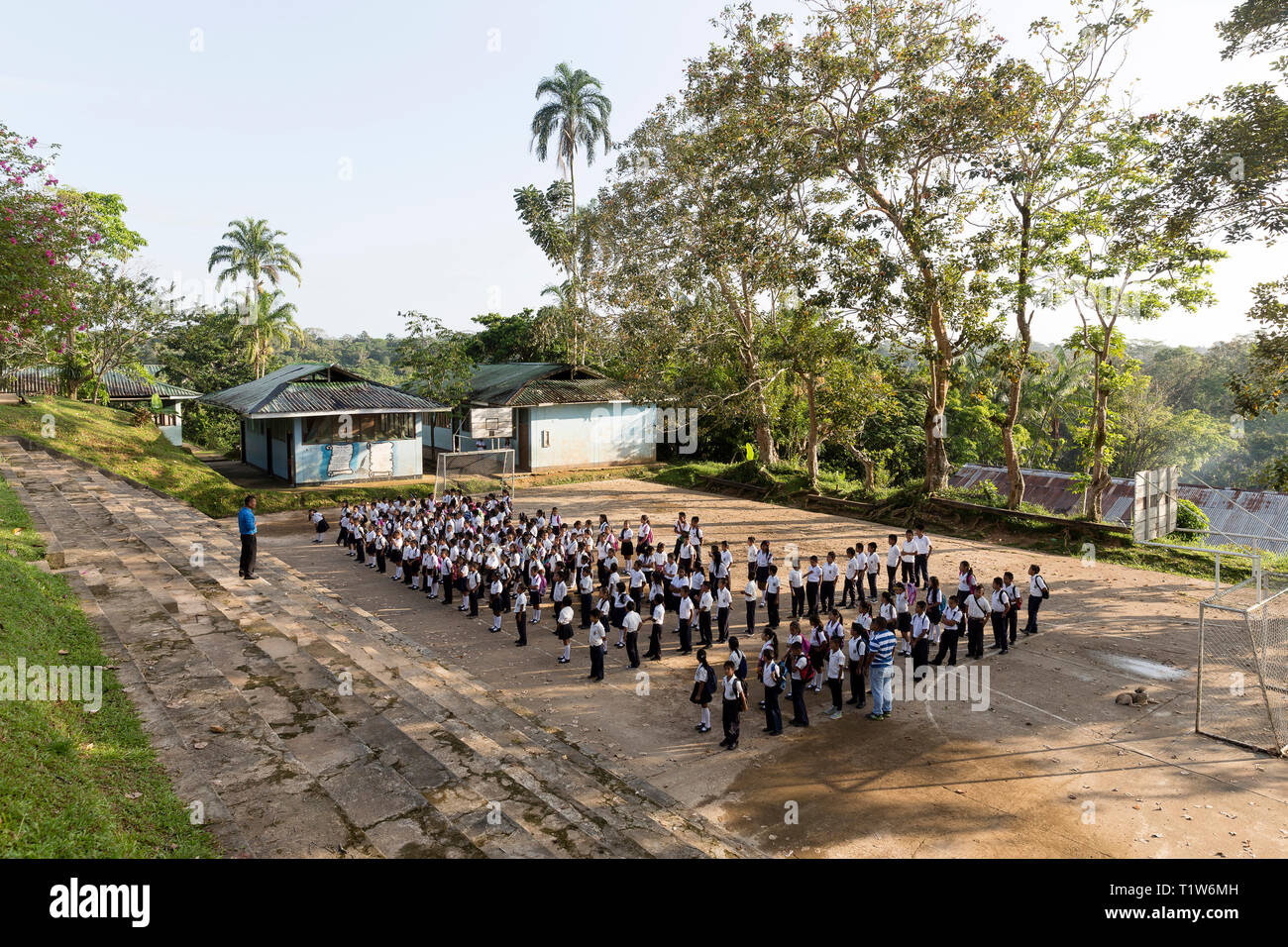 Kolumbien: Abteilung des Amazonas. Zu Beginn des neuen Schuljahres in Puerto Narino. Flagge Anhebung Zeremonie für die Schüler und Schülerinnen in Uniform, in einem Stockfoto