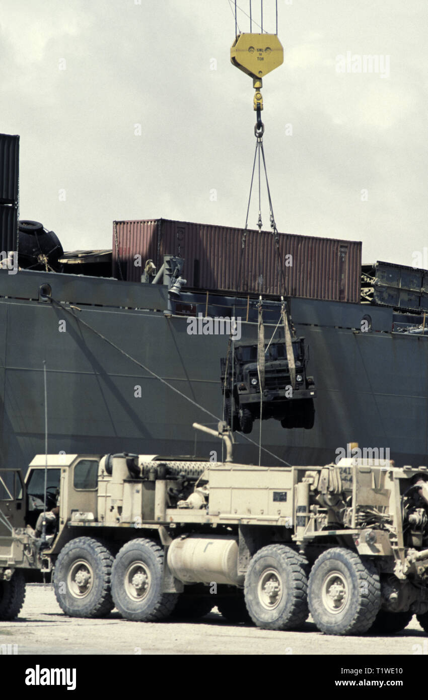 29. Oktober 1993 ein 5-Tonnen-Lkw M939 wird von einem 50-Tonnen-Kran des US Marine Administration Vehicle Frachtschiffes USNS Denebola im neuen Hafen in Mogadischu, Somalia, entladen. Im Vordergrund steht ein M984A2 'Wracker' HEMTT (Heavy Expanded Mobility Tactical Truck), der kürzlich entladen wurde. Stockfoto