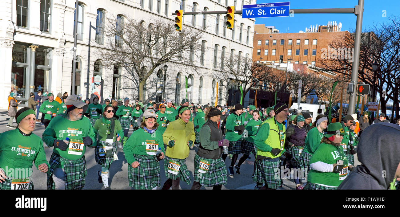 Die weltweit größte kilt Rennen Teilnehmer laufen durch den Warehouse District in Downtown Cleveland, Ohio, USA während der 2019 St. Patrick's Day Event. Stockfoto