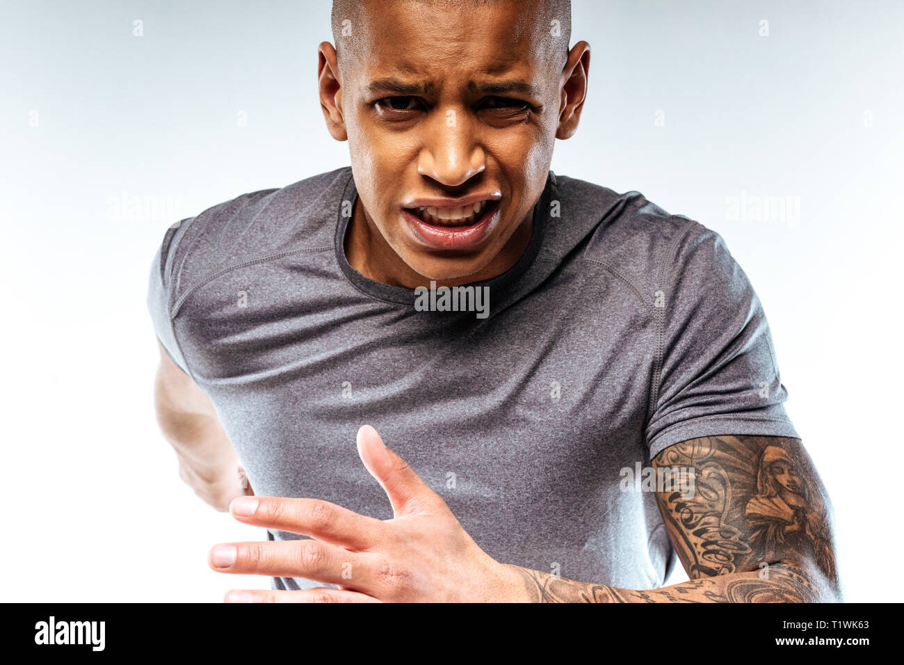Emotionale tattoed Mann Gefühl Schmerz während der Ausführung Stockfoto