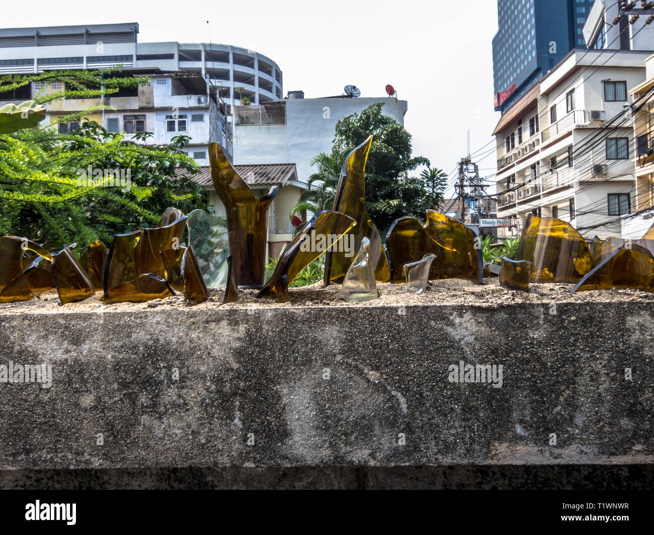 Wand geschützt mit zerbrochenen Flaschen Glas in Bangkok, Thailand Stockfoto